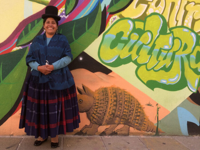 Francisca Alvarado Mamani vor einer bunten Graffitiwand