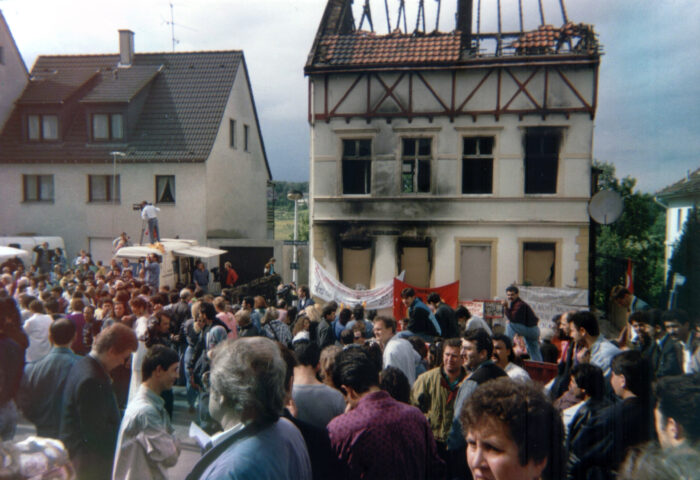 Eine Menschenmenge steht vor dem von Nazis abgebrannten Haus in Solingen.