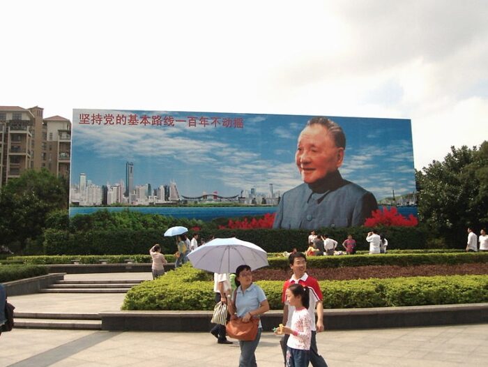 Eine Familie vor einem Wandbild von Deng Xiaoping.