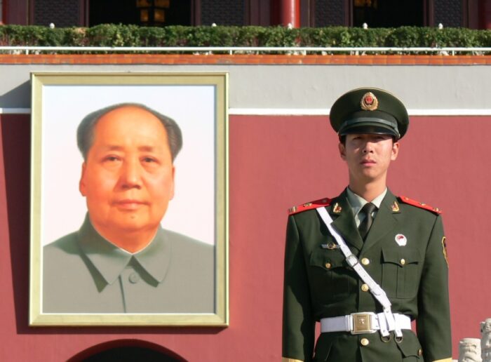 Portrait von Mao, daneben ein Soldat in Haltung