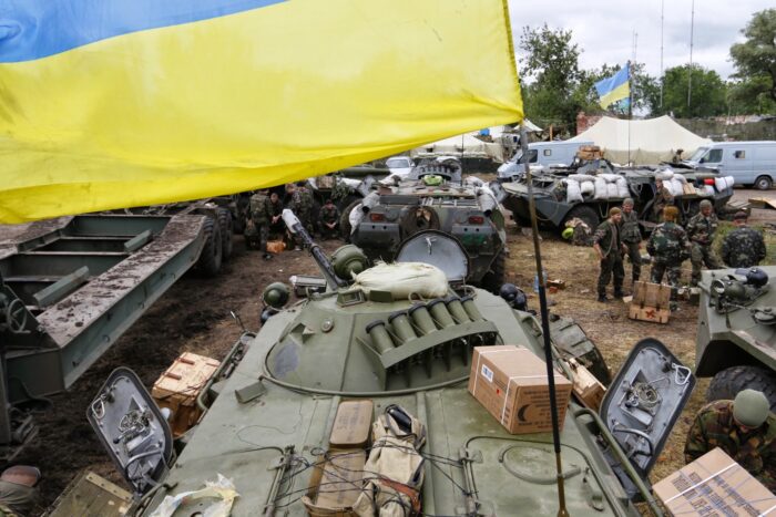 Ein Bild von 2014 aus dem Donbass, man sieht schweres Kriegsgerät und eine Ukrainische Flagge.