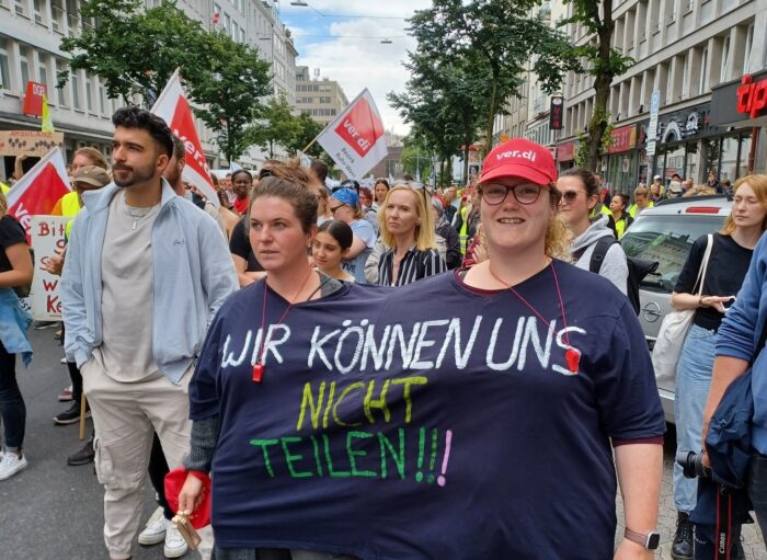 Zwei Personen tragen gemeinsam ein Shirt auf dem steht: Wir können uns nicht teilen.