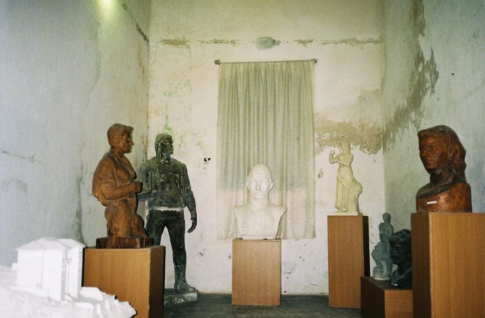 Eine Sammlung alter Büsten und Statuen in einer schlecht beleuchteten Abstellkammer