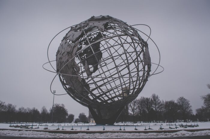Zwei Stockwerke hohe Metallskulptur eines Globus mit Linien, die quer über den Globus gehen.