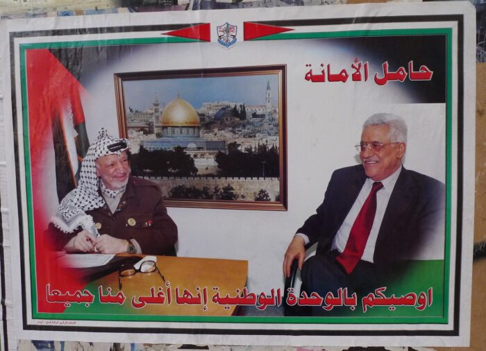 Ein Plakat zeigt Yasir Arafat und Mahmoud Abbas an einem Tisch.