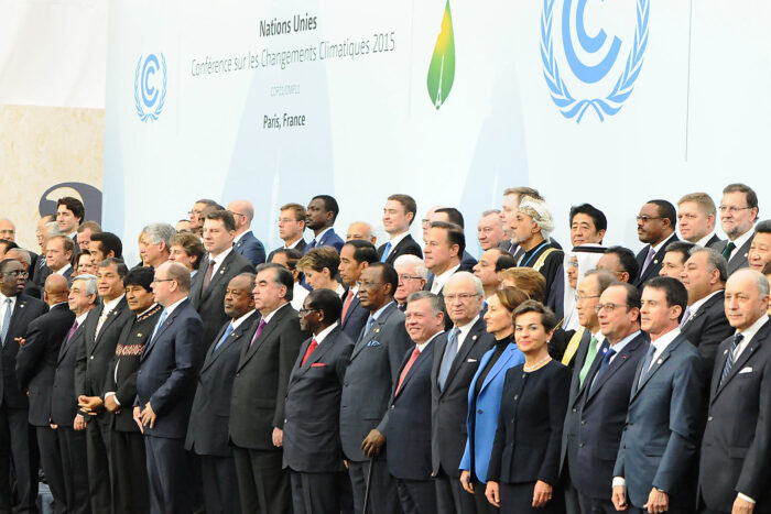 Gruppenfotos von Staatschefs in Anzügen vor einer Leinwand mit den Logos der UN Agentur UNFCCC und der Aufschrift auf französisch "UN Klimakonferenz 2015, Paris, Frankreich"
