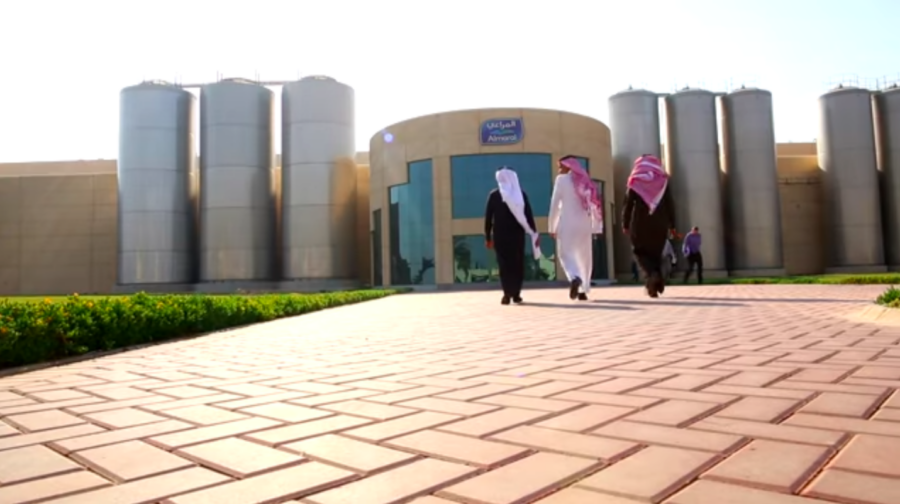Zu sehen ist ein Firmensitz des saudi-arabischen Molkerie- und Lebensmittelkonzern Almarai mit drei Menschen, die auf den Eingang zulaufen.