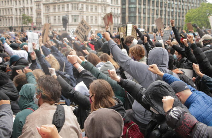 Eine Demonstration reckt geschlossen die rechte Faust in die Höhe