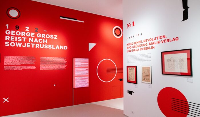 Man sieht einen rot weißen Ausstellungsraum.