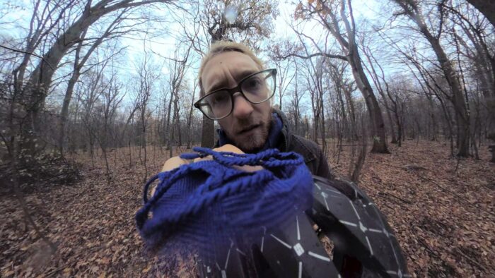 360-grad Bild eines Waldes, im Zentrum Steffen Meyn, der ernst in die Kamera schaut und einen Helm hält, auf dem die Kamera sitzt.