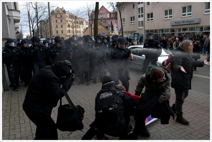 Ein paar Demonstrant*innen werden von Polizist*innen mit Tränengas attackiert.