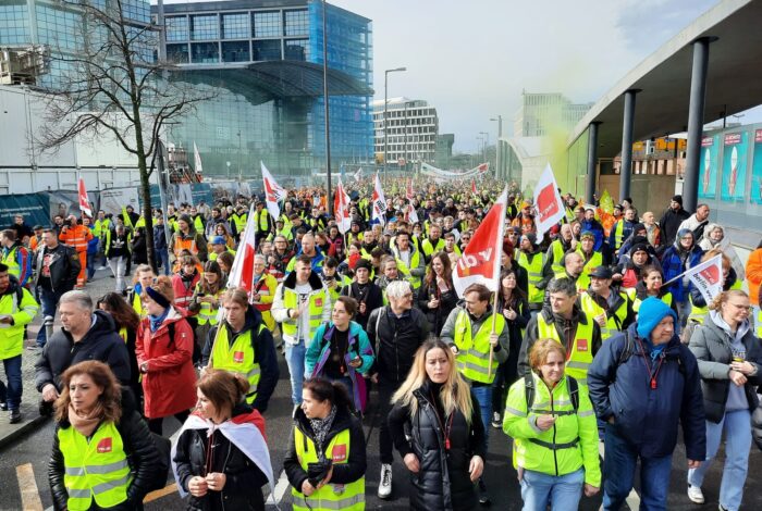 Großer Demonstrationszug von Menschen in gelben Westen und mit ver.diFahnen an einem sonnigen Tag