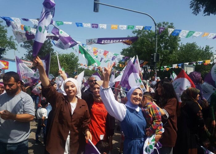 Demonstrierende Frauen, die Victory-Zeichen zeigen, mit Fahnen der Yeşil Sol Parti.