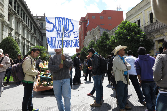 Auf einer Kundgebung in Guatemala Stadt hält ein Mann ein Transparent mit der Aufschrift »Wir sind das Volk, keine Terroristen« in die Höhe