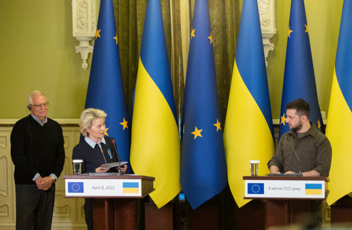 Bild eines diplomatischen Empfangs. Im Hintergrund sind ukrainische und EU-Flaggen zu sehen. Im Vordergrund stehen links Ursula von der Leyen und links Wolodymyr Selenskyj vor Rednerpulten.
