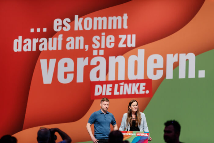 Martin Schirdewan und Janine Wissler stehen auf einer Bühne. Im Hinergrund ist ein Schriftzug "... es kommt drauf an, sie zu verändern. Die Linke."