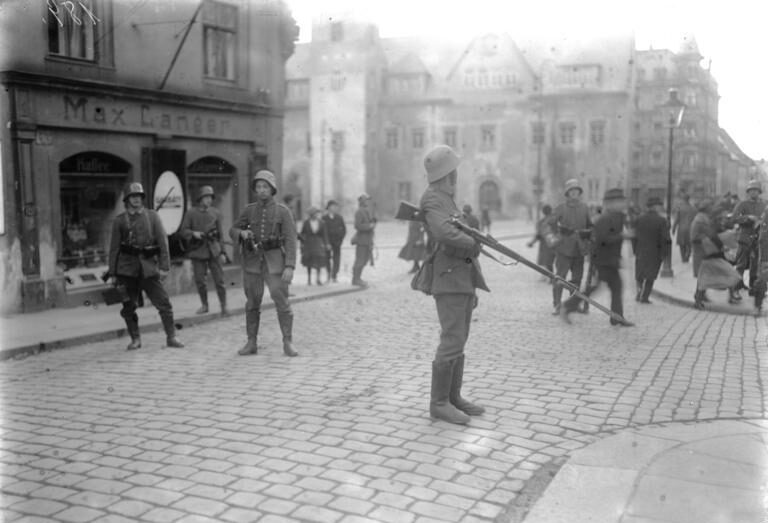 Reichswehr-Soldaten riegeln eine Straße mit gefälltem Bajonett ab