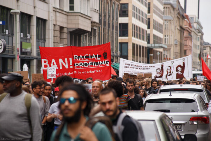 Ein Demozug läuft durch Berlin, im Juni 2017. Auf einem roten Transparent ist zu lesen: Ban Racial Profiling. Gefährliche Orte abschaffen.