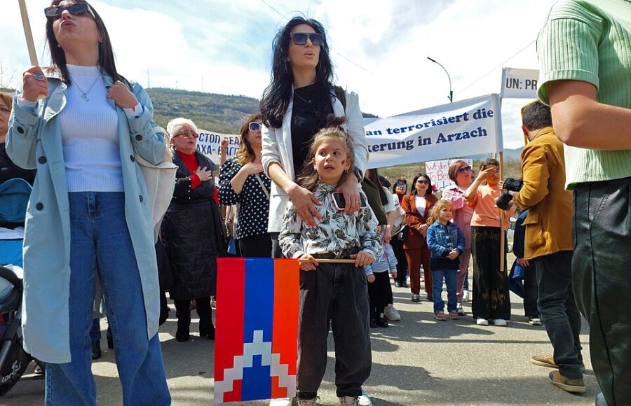 Mehrere Frauen und Kinder sind im April 2023 auf einem Platz in Stepanakert versammelt, halten Transparente in die Höhe und demontrieren gegen die Blockade der Republik Arzach durch aserbaidschanische Truppen.