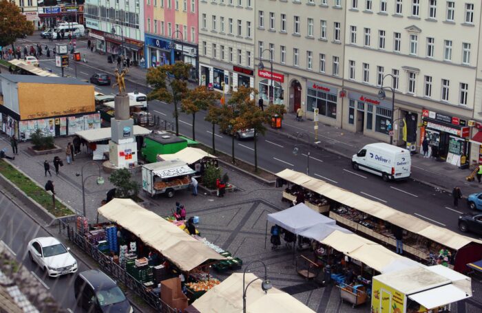 Der Hermannplatz in Berlin Neukölln von oben, mit Marktständen, Menschen, an einem grauen Tag