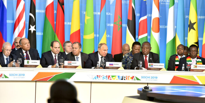 Bild von hohen Staatsrepresentanten mit Schildern ihrer Länder Simbabwe, Südafrika, Ägypten und Algerien. In der Mitte Putin. Im Hintergrund Flaggen afrikanischer Staaten