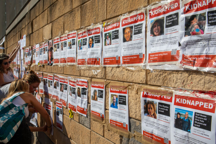 Eine Mauer mit Plakaten, auf denen Porträts von Menschen und ein kurzer Text zu sehen sind, darüber steht "kidnapped".