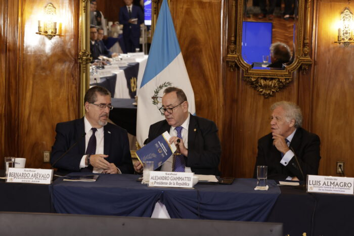 Drei Personen an einem Tisch sitzend, einer davon der designierte Präsident Guatemalas.
