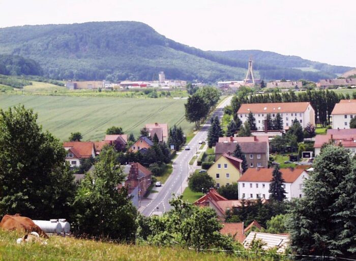 Straße durch den Ort Bischofferode, im Hintergrund der alte Kali-Schacht