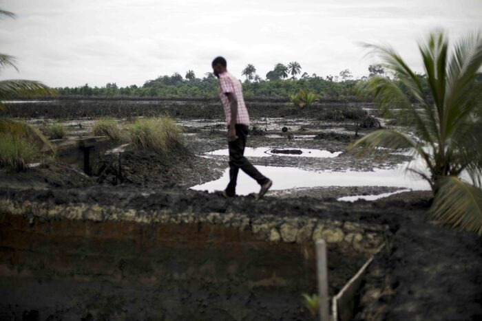 Ein Mann läuft über eine von Erdöl zerstörten Landschaft
