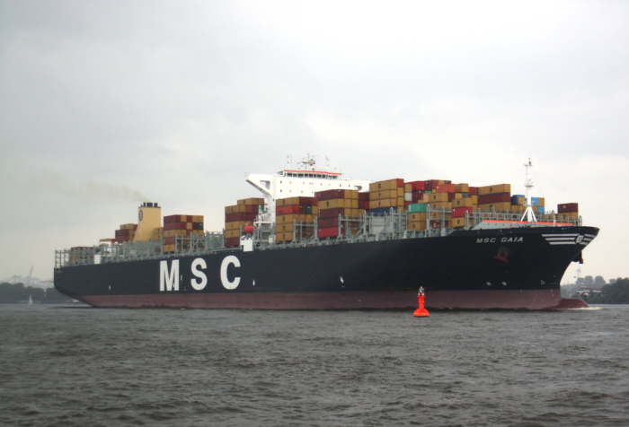 Ein großes Schiff mit Containern beladen und der Aufschrift MSC fährt die Elbe hinunter.