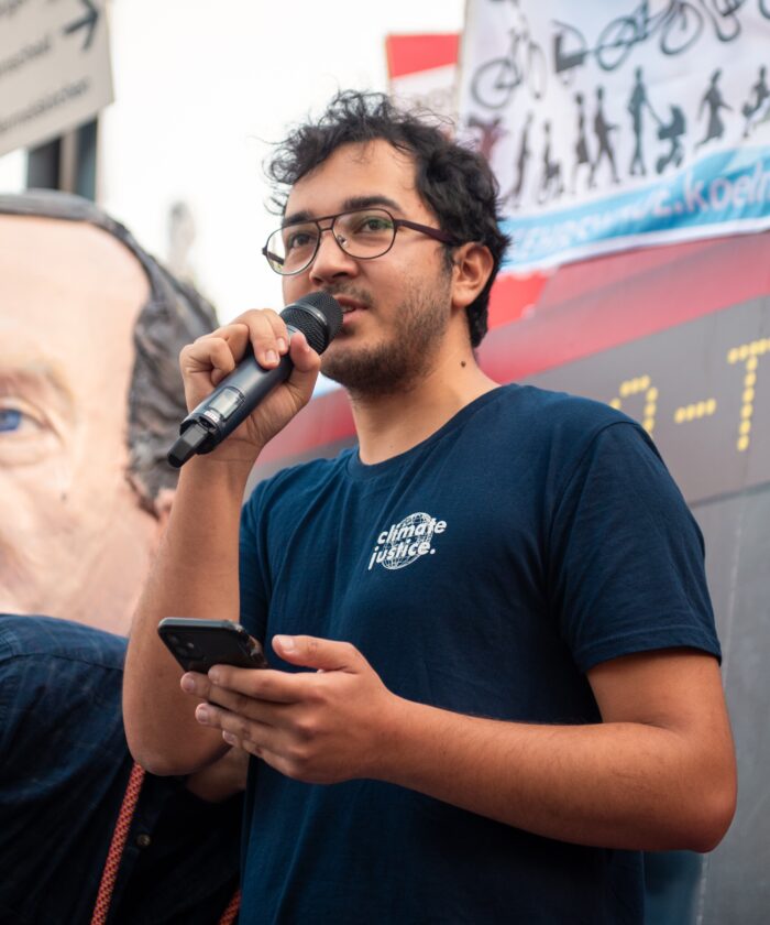 Amadeo Klaus spricht auf einer Demonstration in ein Mikrofon.