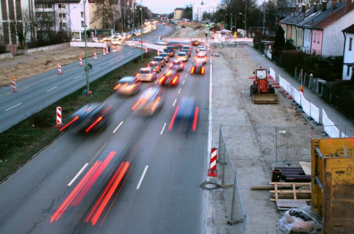 Autos fahren eine Straße entlang und werden durch eine Baustelle gebremst