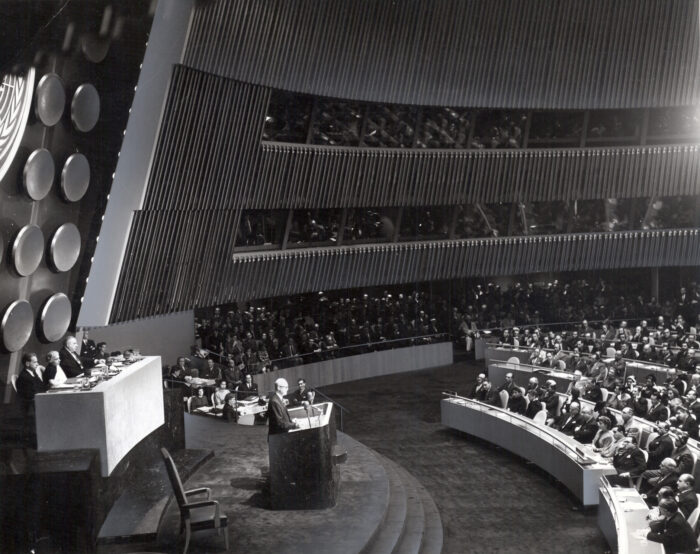 Historische Aufnahme vom Versammlungsraum der Uno Generalversammlung. Ein Redner steht am Pult und spricht vor eine Reihe Delegierten.