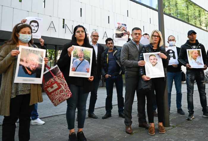 Mehrere Menschen stehen, mit etwas Abstand zu einander, vor einem Gebäude mit der Aufschrift Landtag. Sie halten große ausgedruckte Fotos von mehreren am 19. Februar 2020 in Hanau ermordeten Menschen hoch.