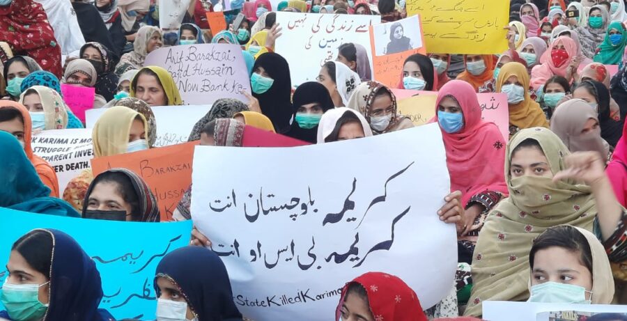 Frauen demonstrieren mit verschiedenen Postern auf Urdu und Englisch, auf denen Gerechtigkeit für Karima Baloch gefordert wird.