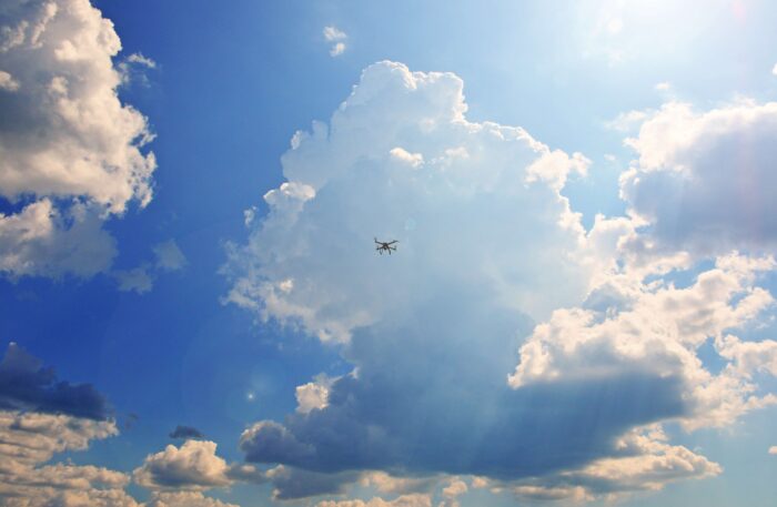 Drohne vor blauem Himmel mit großen Wolkenbergen