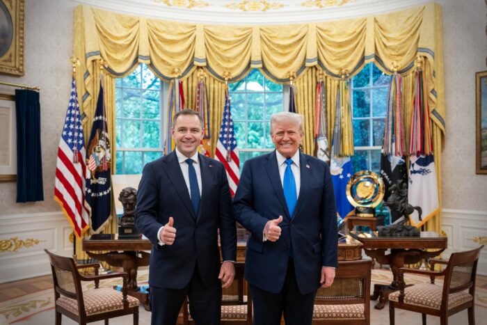 Karol Nawrocki und Donald Trump grinsen im Oval Office vor goldenen Vorhängen und USA-Fahnen in die Kamera und zeigen Daumen hoch