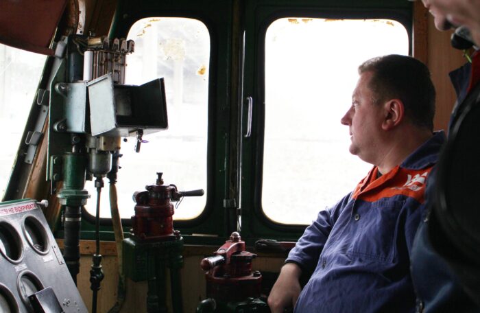 Ein Eisenbahnfahrer sitzt in der Fahrerkabine und schaut aus dem Fenster