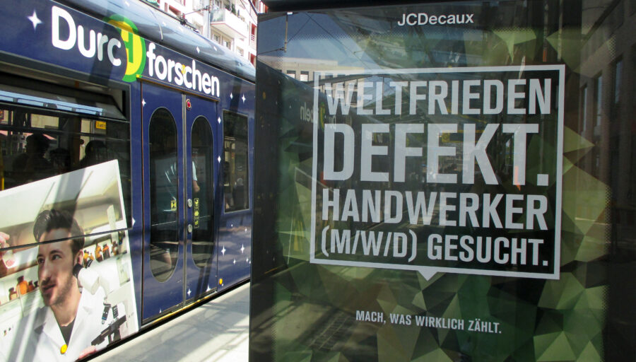 Man sieht ein Werbeplakat der Bundeswehr auf dem steht: Weltfrieden defekt. Handwerker gesucht.