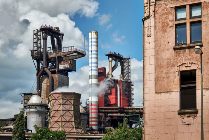 Hochofen und Industrieanage, im Vordergrund sind Teile der Fasssade eines Wohnhauses zu sehen