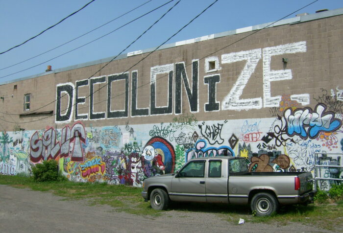 Man sieht ein Decolonize Graffiti.
