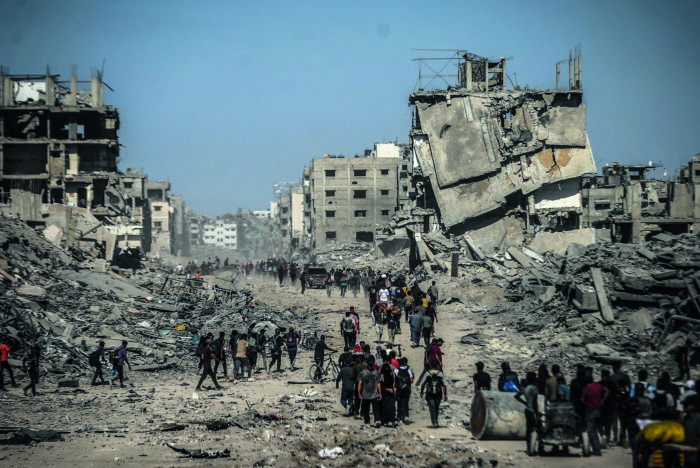 Foto von zertrümmerten und zerstörten Wohnhäusern in Gaza vor blauem Himmel