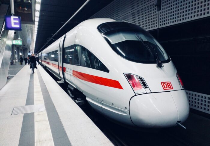 Das Foto zeigt einen ICE am Berliner Hauptbahnhof. Eine Person läuft auf dem Bahnsteig in Richtung der offenen Tür des Zuges