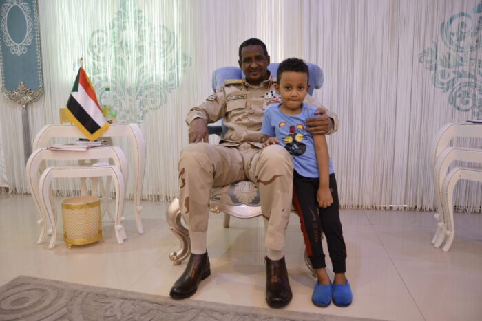 Muhammad Hamdan Daglo alias Hemedti auf einem Stuhl sitzend mit kleinem Kind