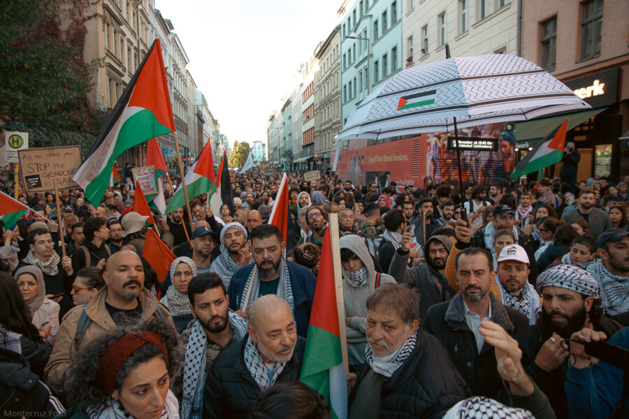 Protestierende auf einer Palästina-Demo in Berlin tragen Kuffiyas und halten Palästina-Flaggen.