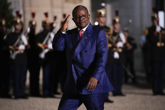 Der guineische Präsident, im Anzug, läuft vor aufgereihten Soldaten und macht einen militärischen Gruß.