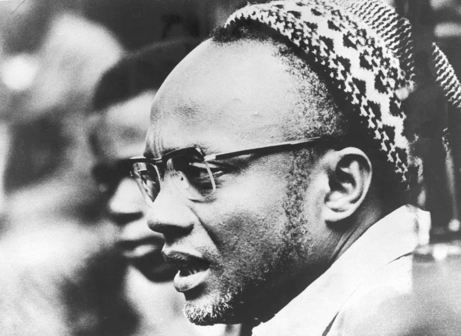 Nahaufnahme von Amílcar Cabral, der sich mit einer Person Abseits des Bildes unterhält.