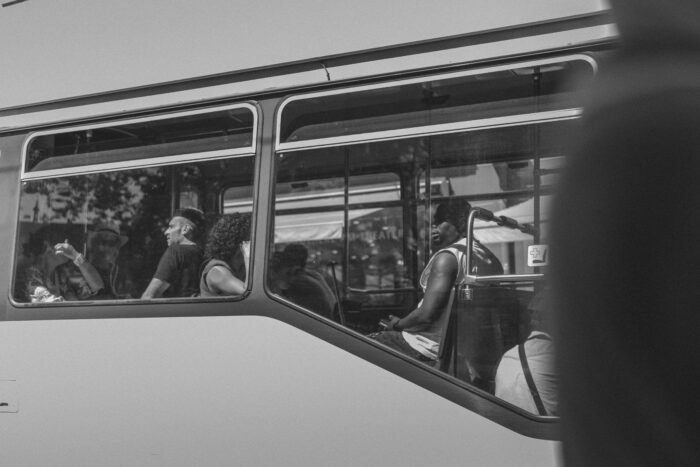 Seitenaufnahme von Menschen, die in einem Bus sitzen.