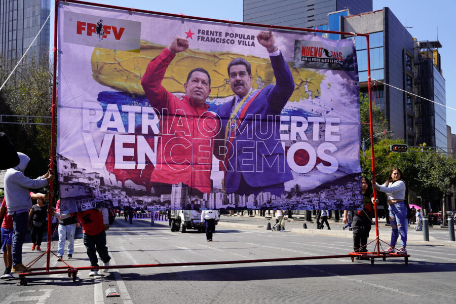 Man sieht ein Großplakat, auf dem Chavez und Maduro zu sehen sind.