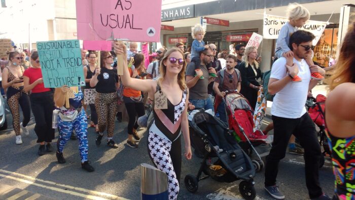 Das Bild zeigt eine Klimastreik-Demo in Bristol. Viele Menschen sind mit Kindern unterwegs, die Sonne scheint und die Stimmung scheint gut.
